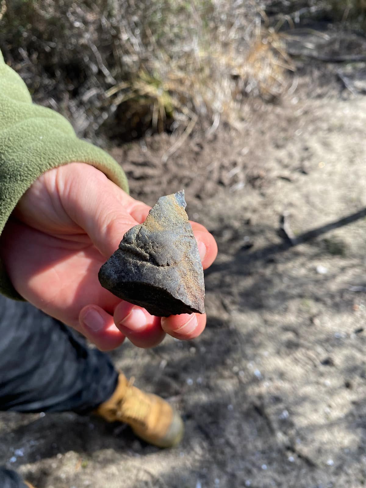 HAND HOLDING STONE TOOL
